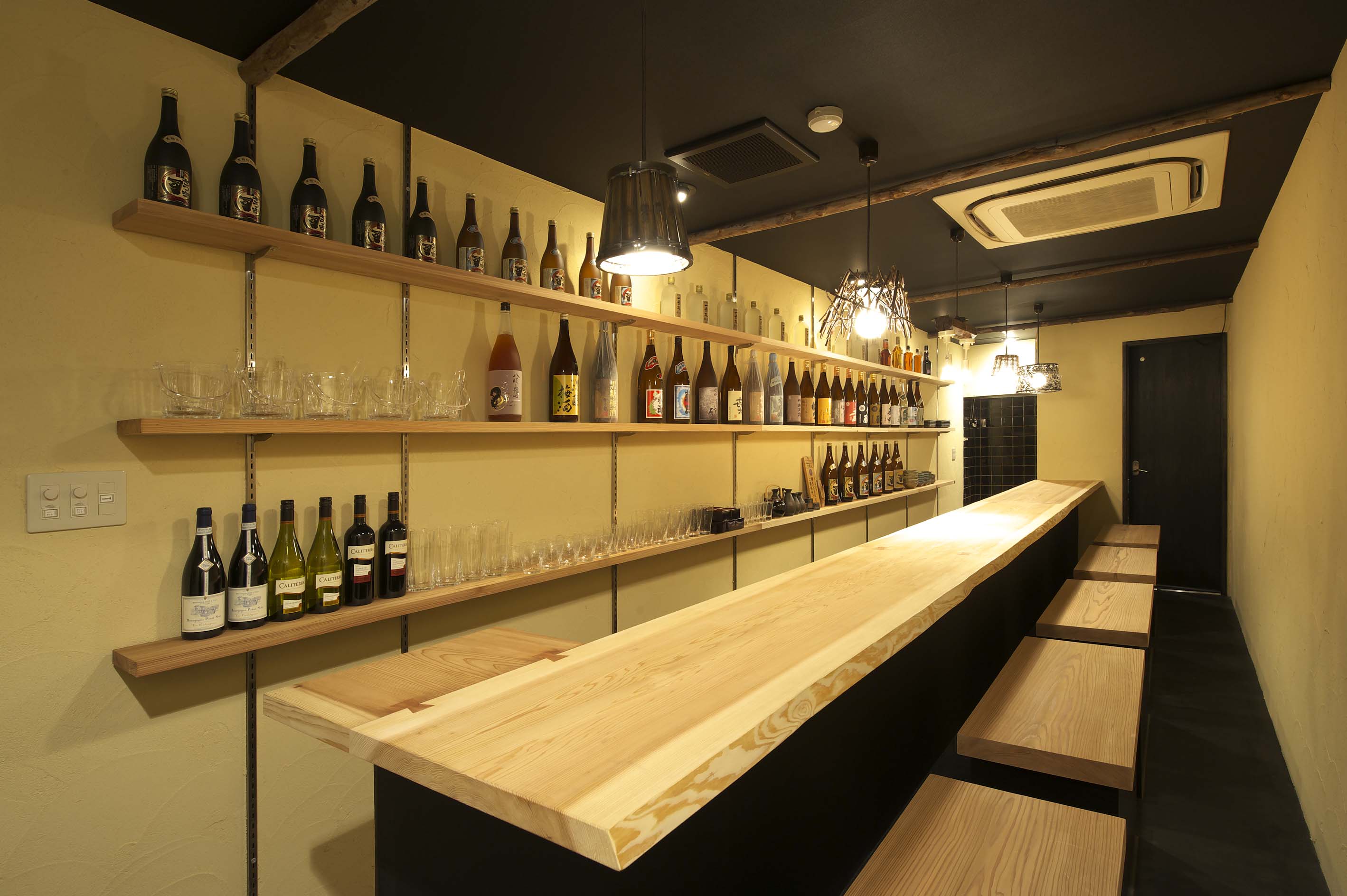 丸石手洗い鉢と流木柱のトイレ（大阪市中央区の和風BAR）